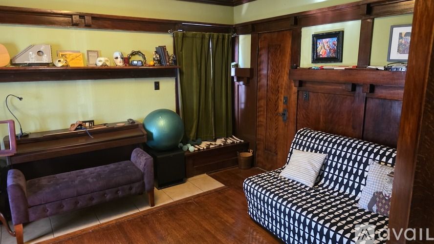 A living room with a purple couch and a black and white checkered couch.