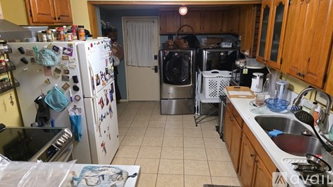 A kitchen with a white fridge and wooden cabinets.