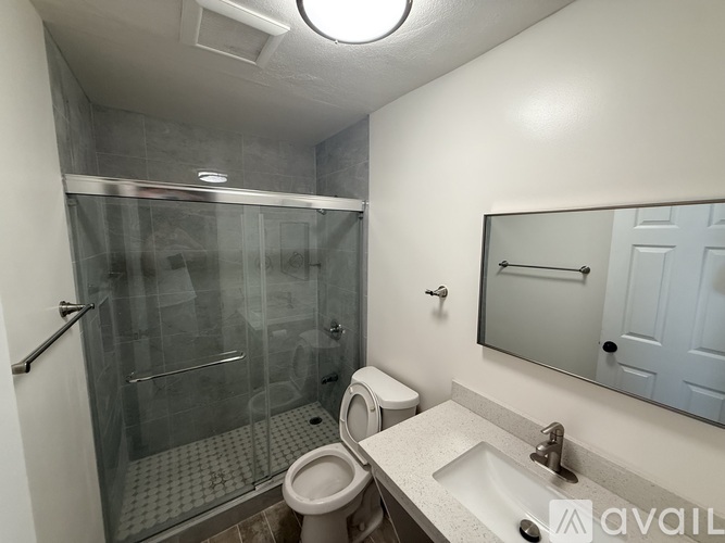 A bathroom with a toilet, sink, and shower.