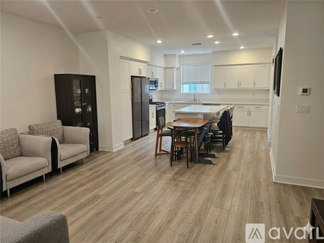 A well-lit kitchen and dining area with wooden flooring and modern furniture.