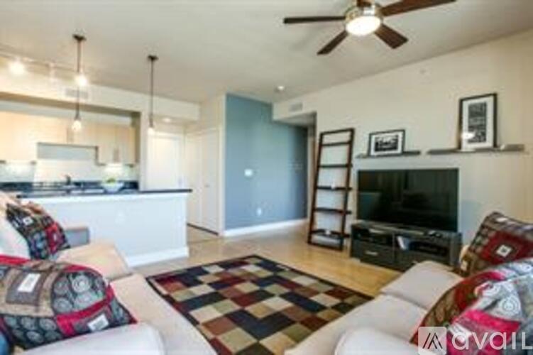 A living room with a checkered rug and a white couch.