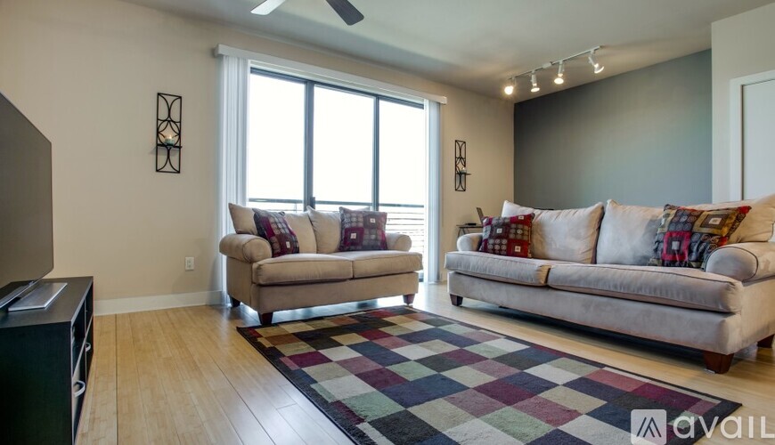 A living room with two couches and a rug.