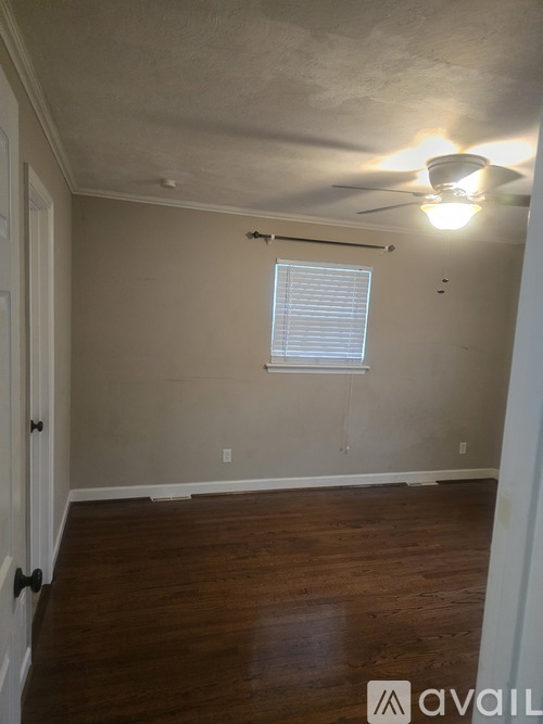 A room with a window and a ceiling fan.