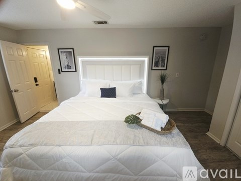 A bedroom with a large bed and two pictures on the wall.