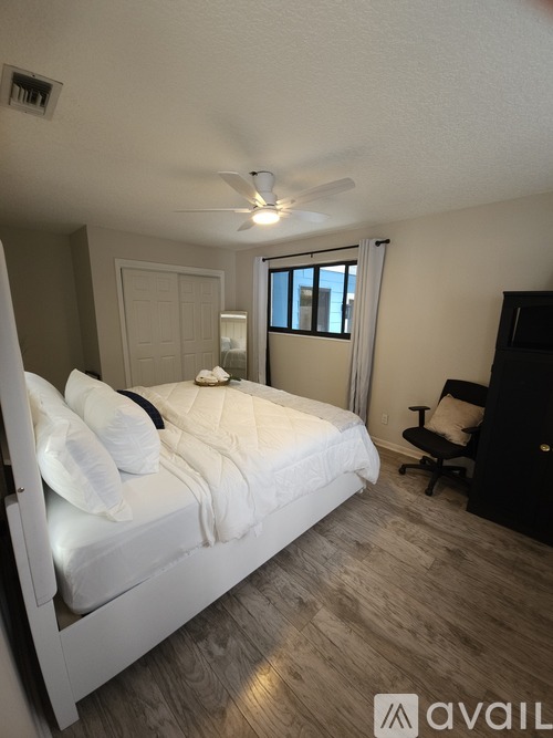 A bedroom with a bed, chair, and window.