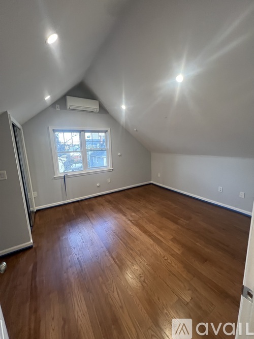 A room with wooden flooring and a window.