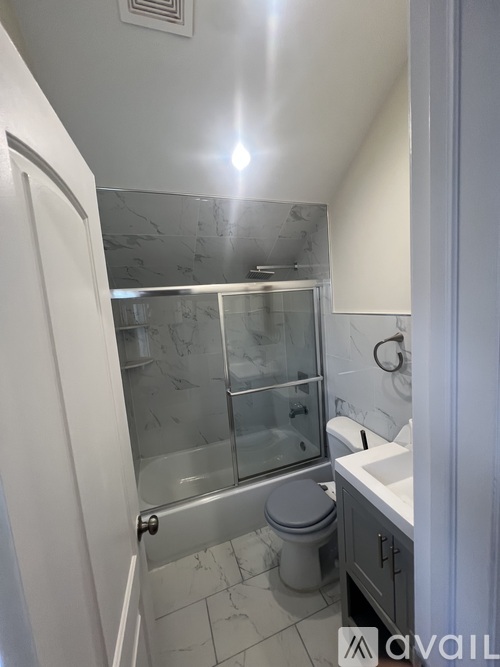 A bathroom with a toilet, sink, and shower.