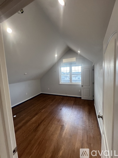 A room with wooden flooring and white walls.