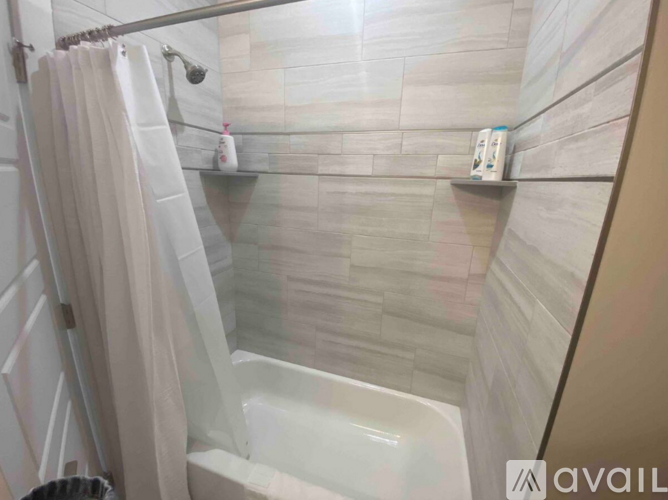 A bathroom with a white tub and a shower curtain.