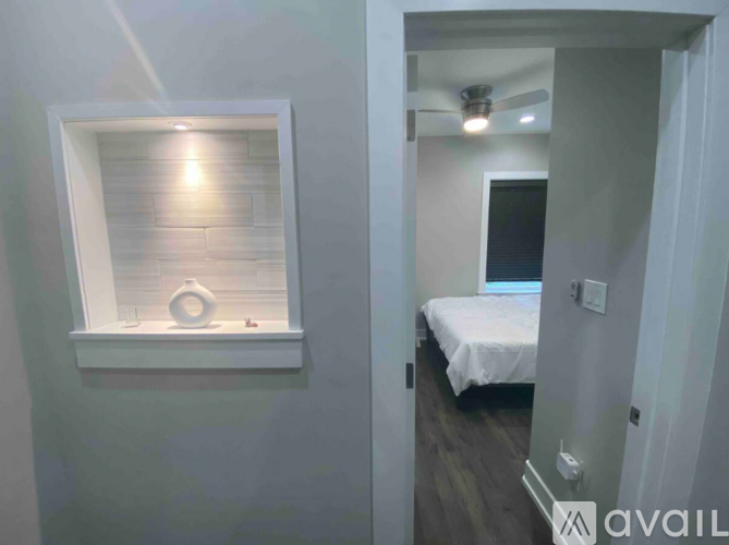 A bedroom with a bed and a window with a light on.