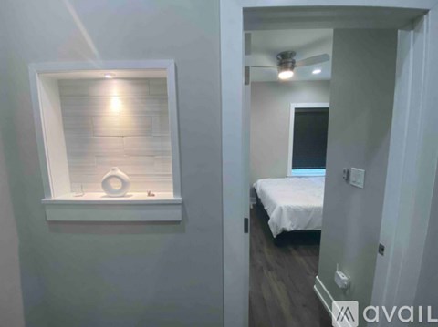 A bedroom with a bed and a window with a light on.