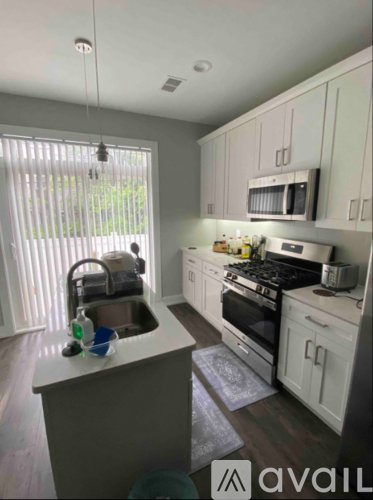 A kitchen with a sink, stove, and cabinets.