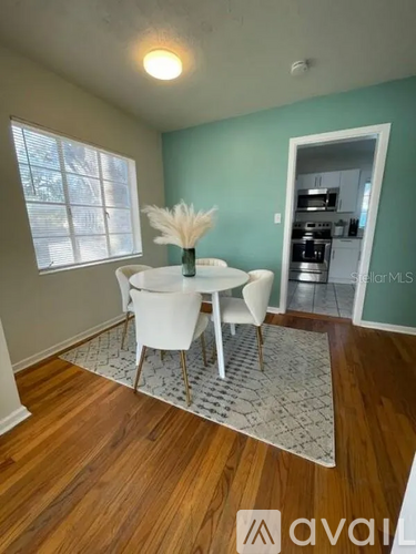 A dining room with a white table and chairs.