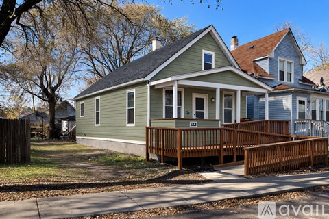 A house with a green front and a brown deck.