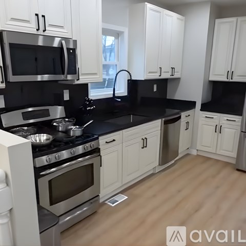A kitchen with black countertops and white cabinets.