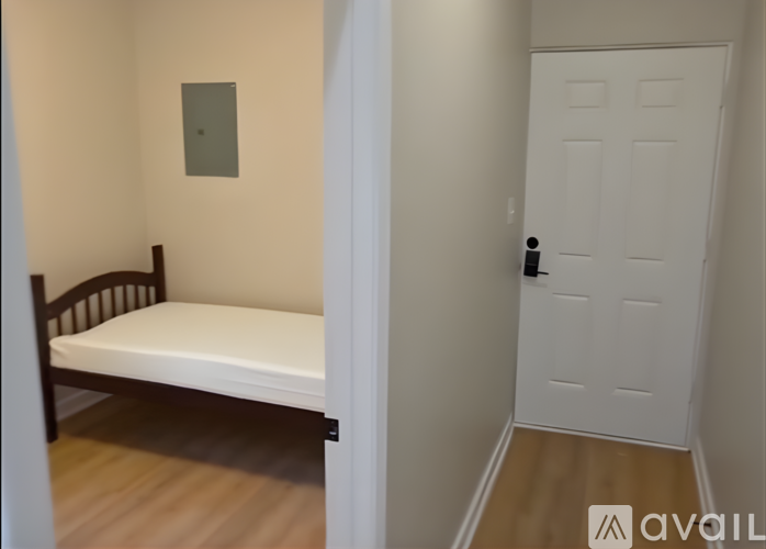 A small bedroom with a bed and a door.