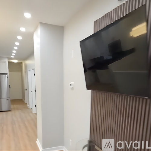 A modern living room with a flat screen TV mounted on the wall.