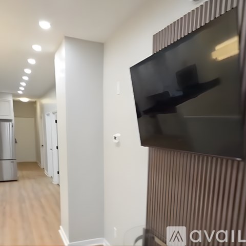 A modern living room with a flat screen TV mounted on the wall.