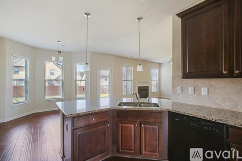 A kitchen with dark wood cabinets and a granite countertop.