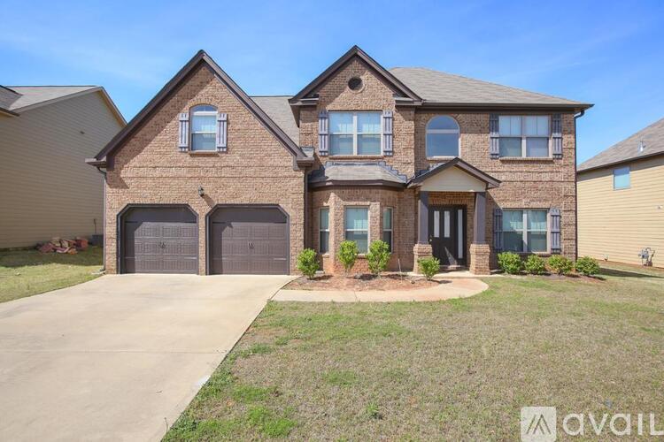 A large brick house with a driveway in front.