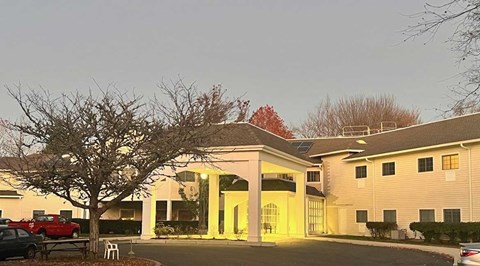 A building with a red car parked in front of it.