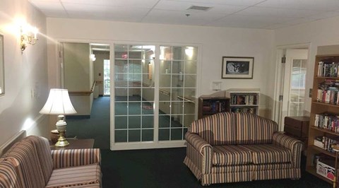 A living room with two striped couches and a lamp.