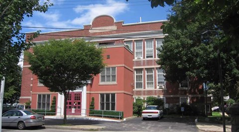 A red brick building with a red door and windows.