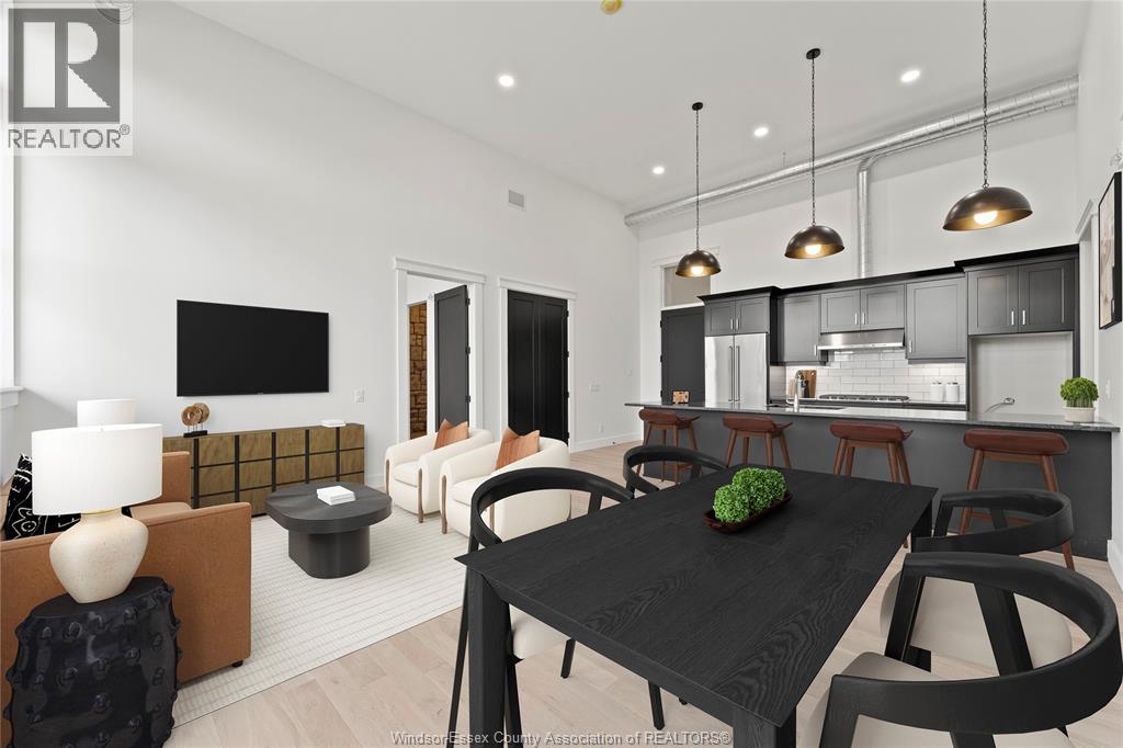 A modern dining room with a black table and chairs.