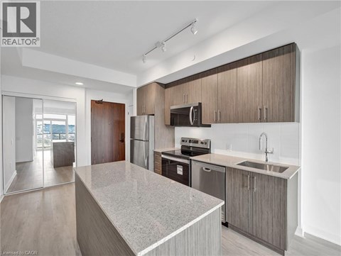 A modern kitchen with wooden cabinets and stainless steel appliances.