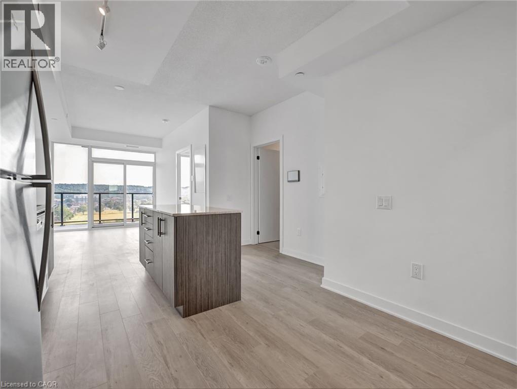 A spacious, empty room with a wooden cabinet and a large window overlooking a body of water.