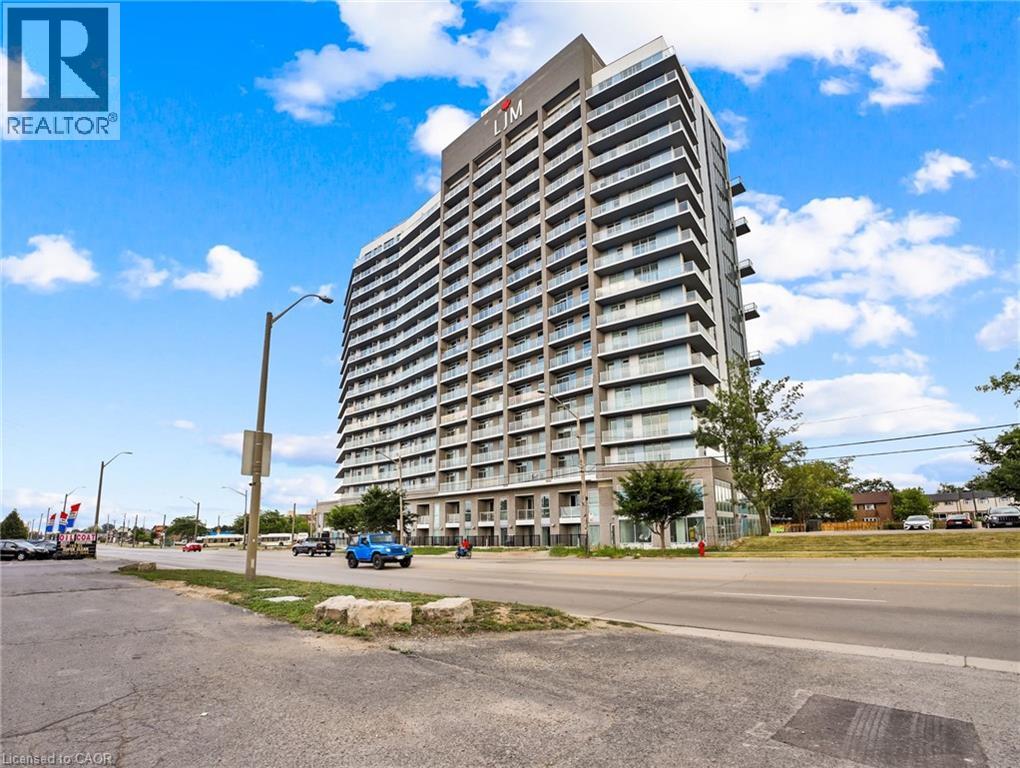 A tall residential building with a blue car parked in front.