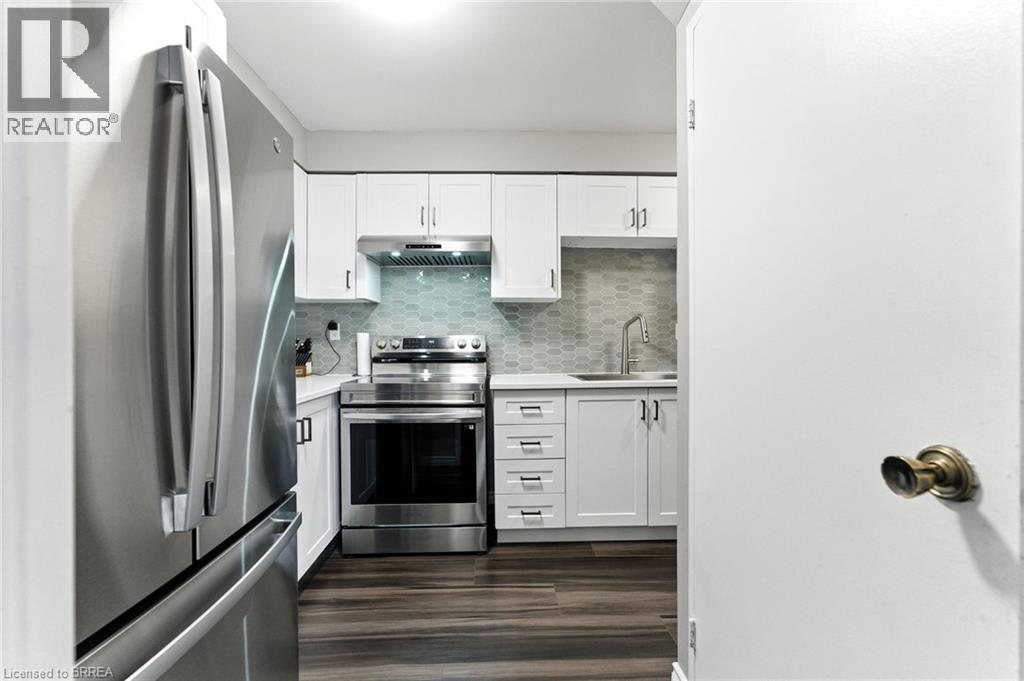 A modern kitchen with white cabinets and stainless steel appliances.