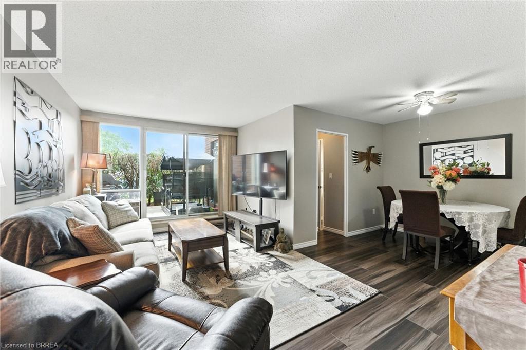 A living room with a brown leather couch and a grey sofa.