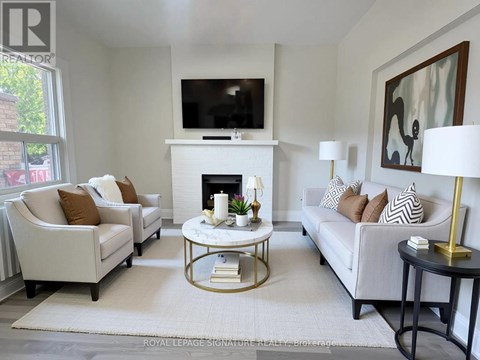 A living room with a fireplace and a television on the wall.
