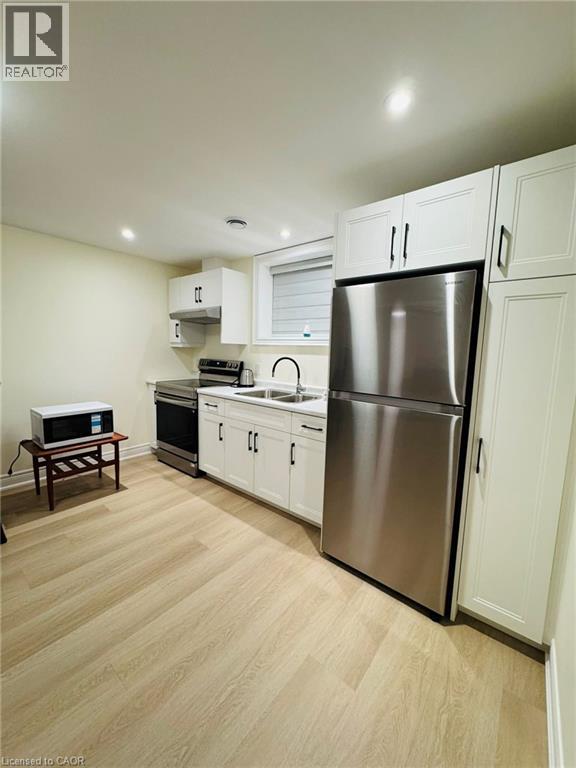 A kitchen with a refrigerator, oven, and microwave.