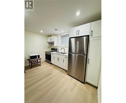 A kitchen with a refrigerator, oven, and microwave.