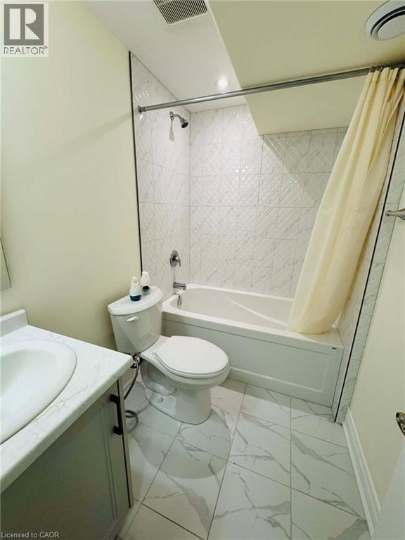 A bathroom with a toilet, sink, and bathtub.