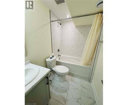 A bathroom with a toilet, sink, and bathtub.
