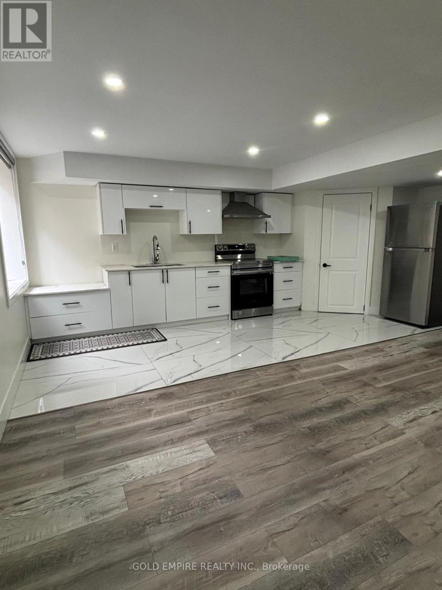 A kitchen with white cabinets and a wooden floor.