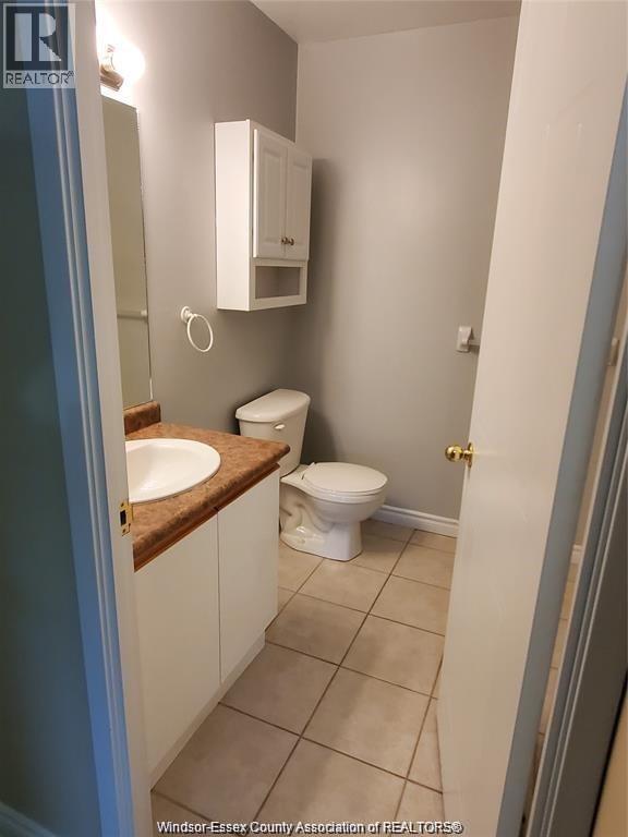 A bathroom with a toilet, sink and medicine cabinet.