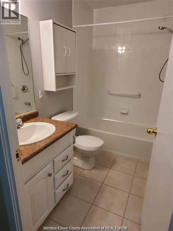 A bathroom with a toilet, sink, and shower.