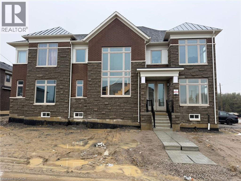 A house under construction with a grey concrete walkway leading to the front door.