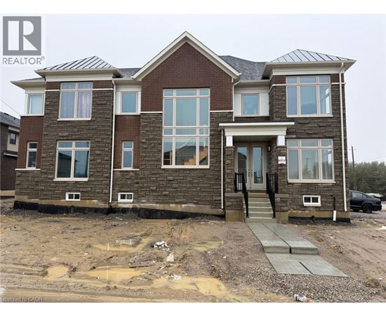 A house under construction with a grey concrete walkway leading to the front door.