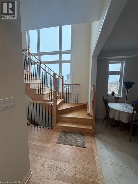 A wooden staircase with a metal railing leads to a dining area with a table set for two.