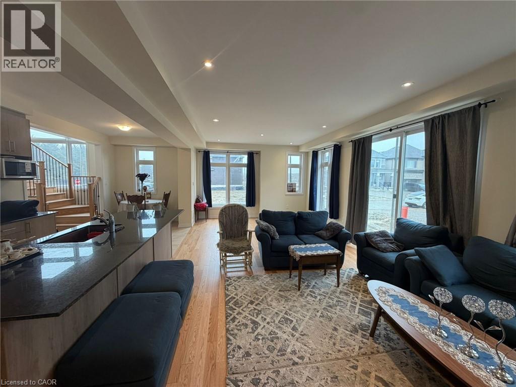 A living room with a black sofa and a wooden floor.