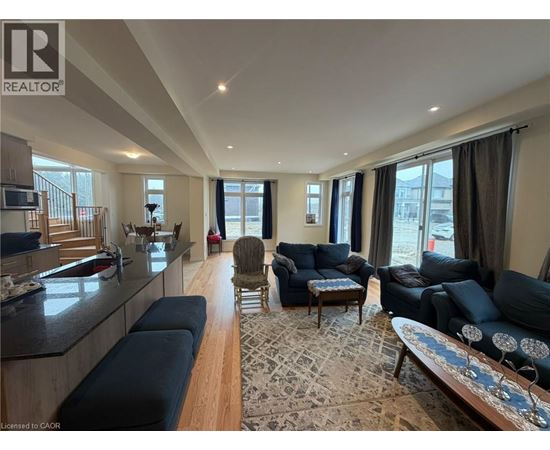 A living room with a black sofa and a wooden floor.