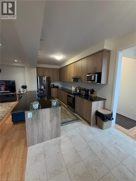 A modern kitchen with wooden cabinets and a black countertop.