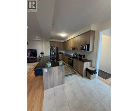 A modern kitchen with wooden cabinets and a black countertop.