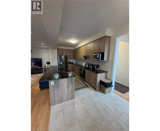 A modern kitchen with wooden cabinets and a black countertop.