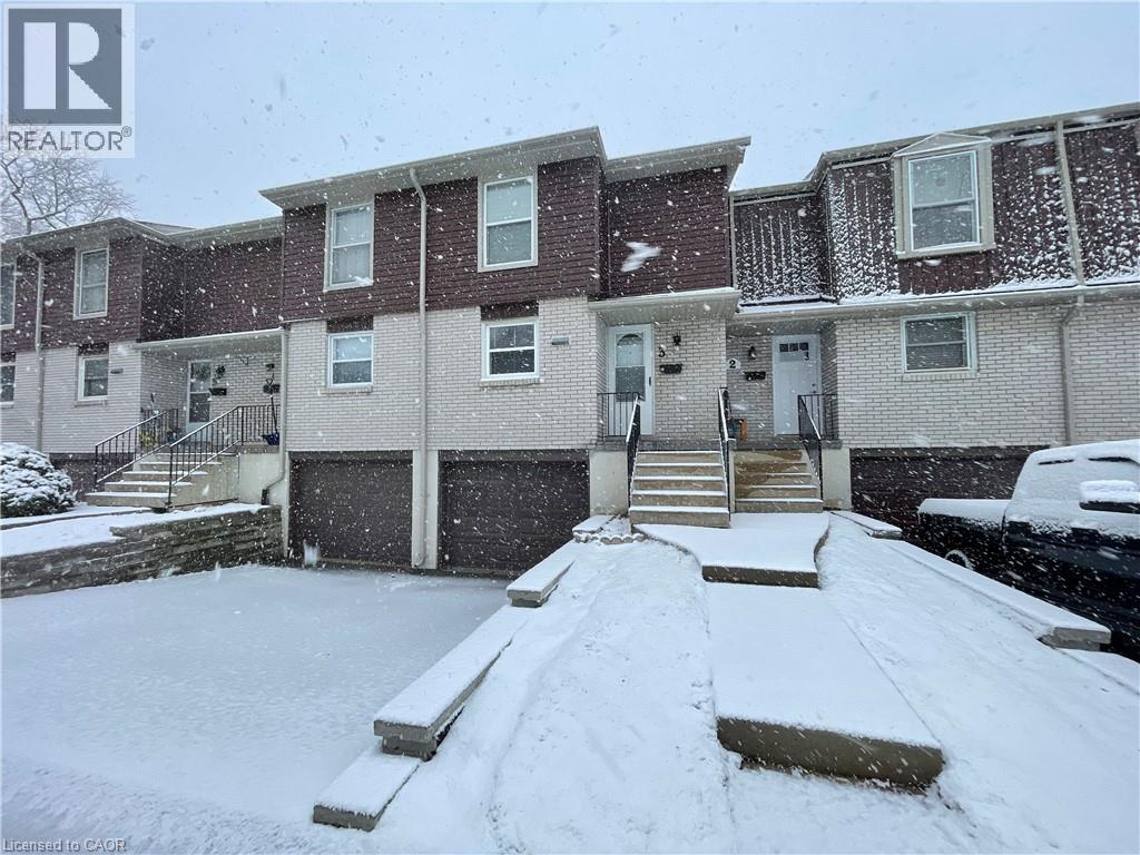 A snow-covered front yard of a residential building.